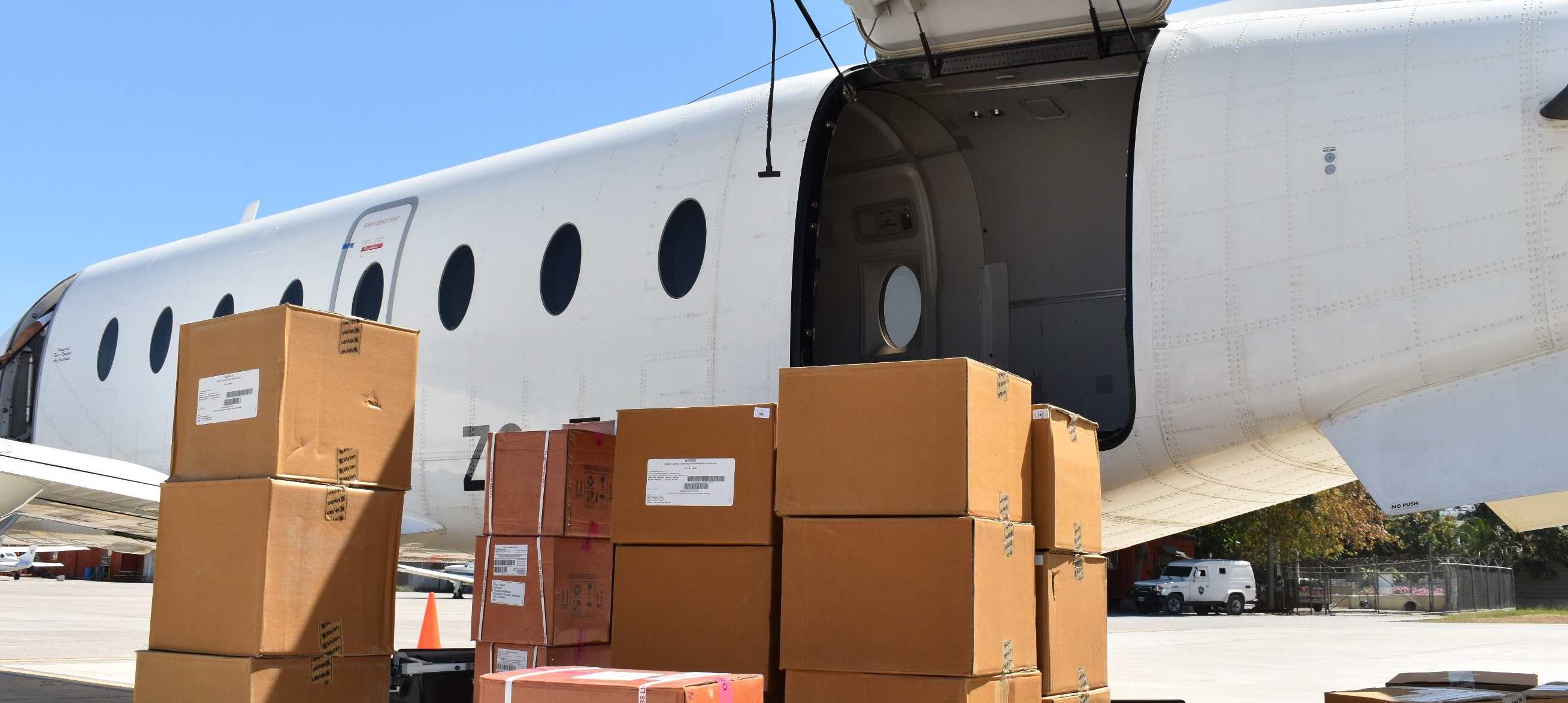 boxes sit in front of airplane for loading