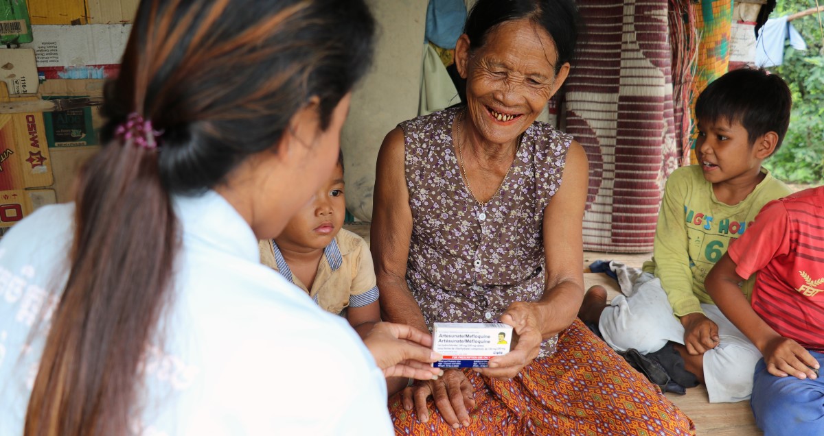 A volunteer malaria worker distributes a box of ACTs in Battambang Province, Cambodia.