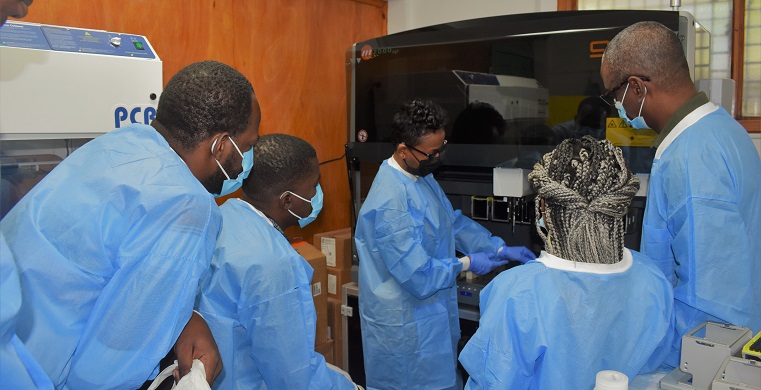 Lab specialists in Haiti being training on a new lab testing machine.