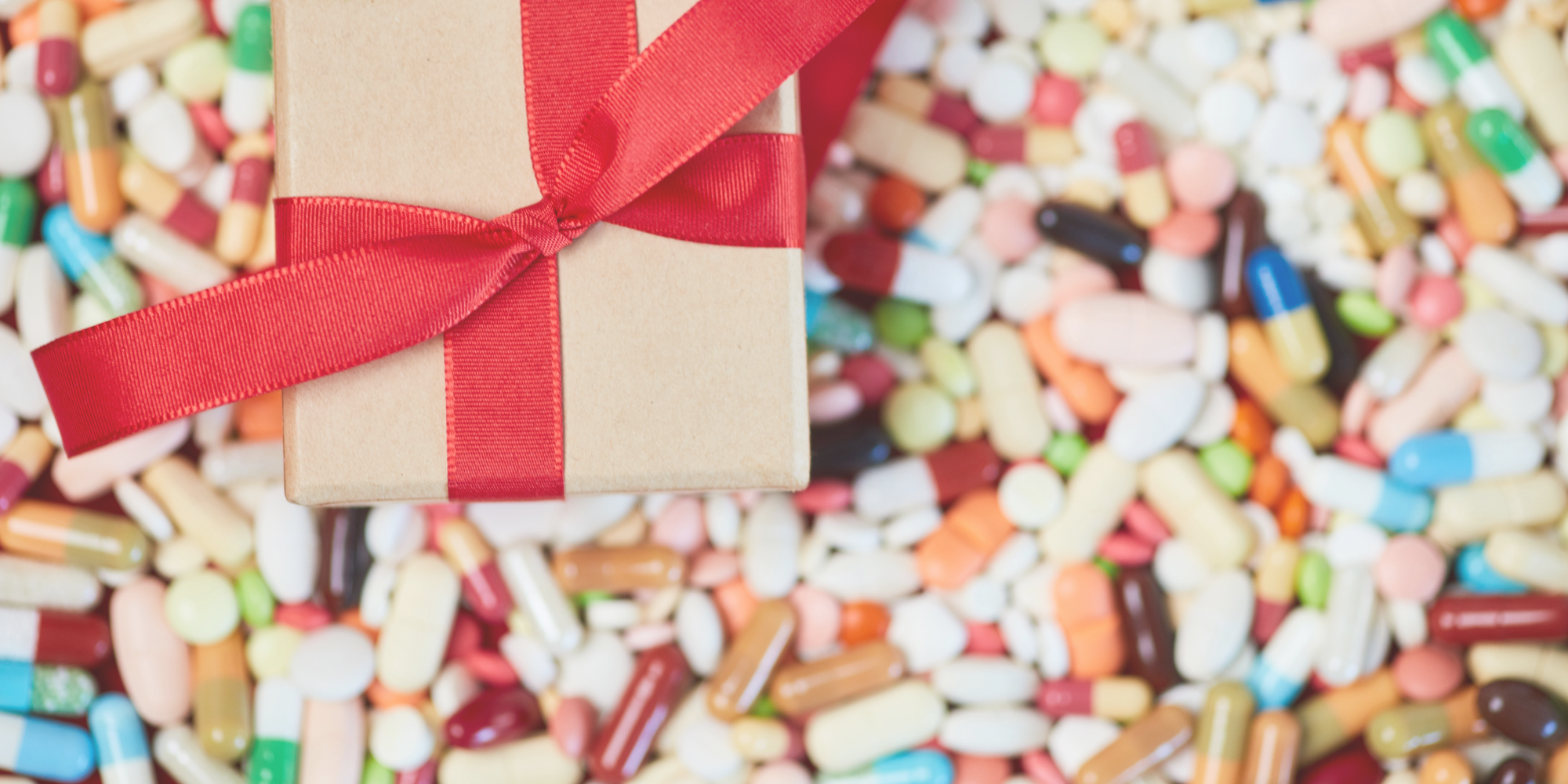 A picture of an unopened gift against a background of pills and medicines.