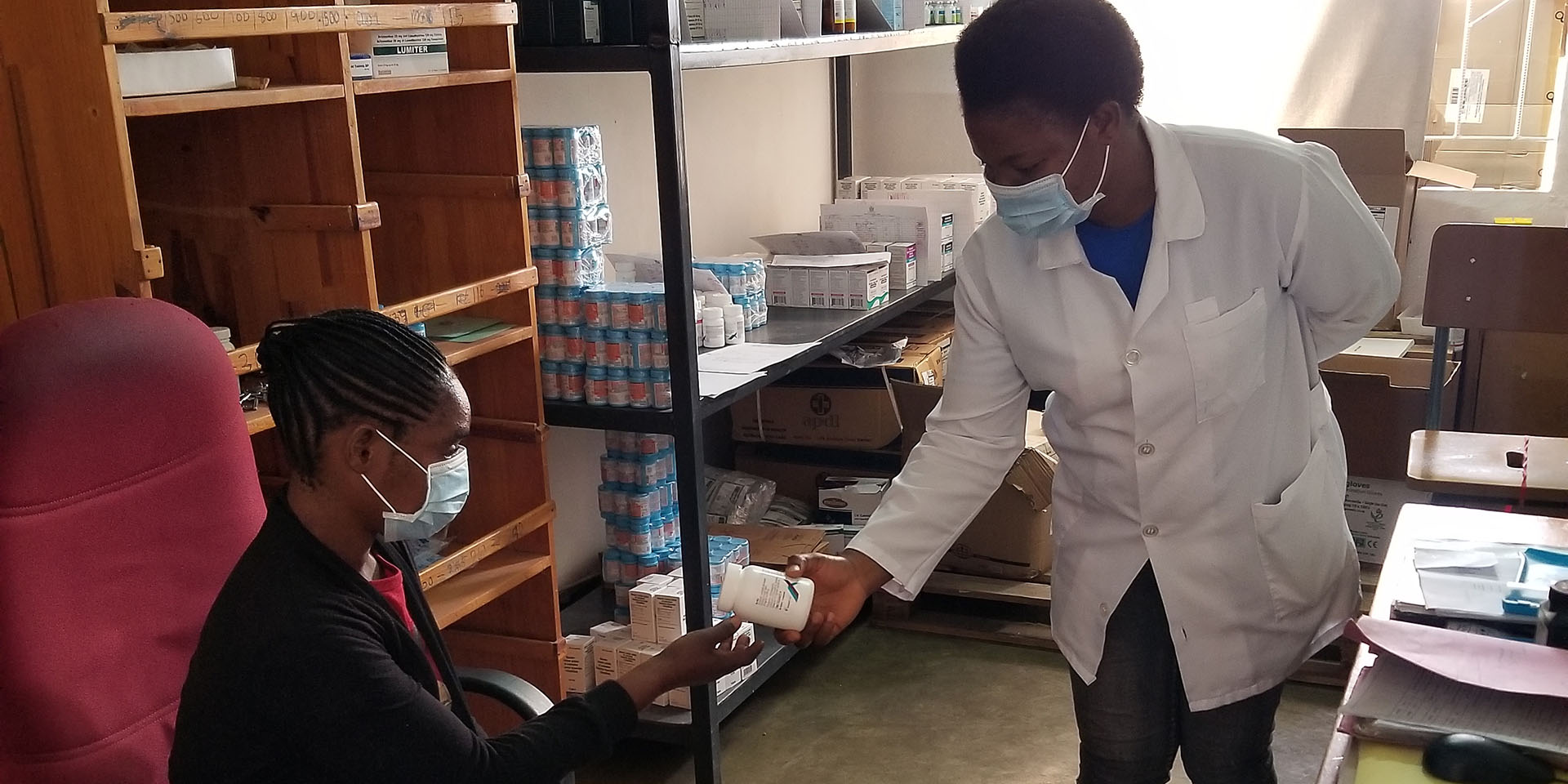 A doctor in Zambia passing medicine to a patient