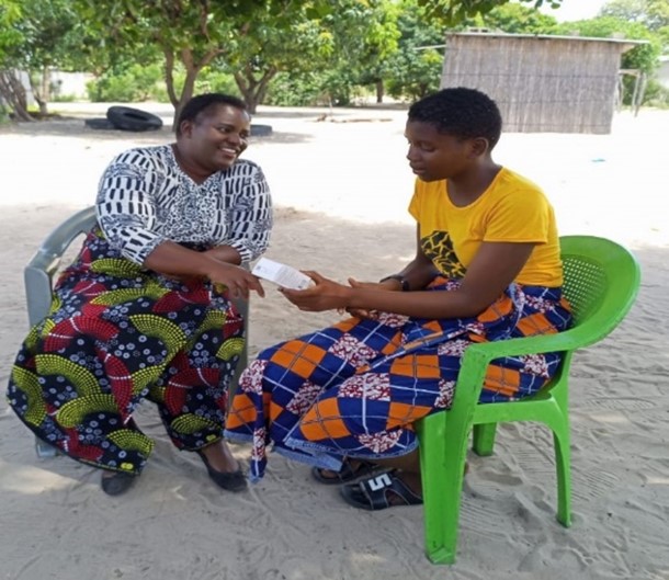 Site Coordinator Priscilla Makasa and Gloria discuss challenges during a community PrEP refill event.