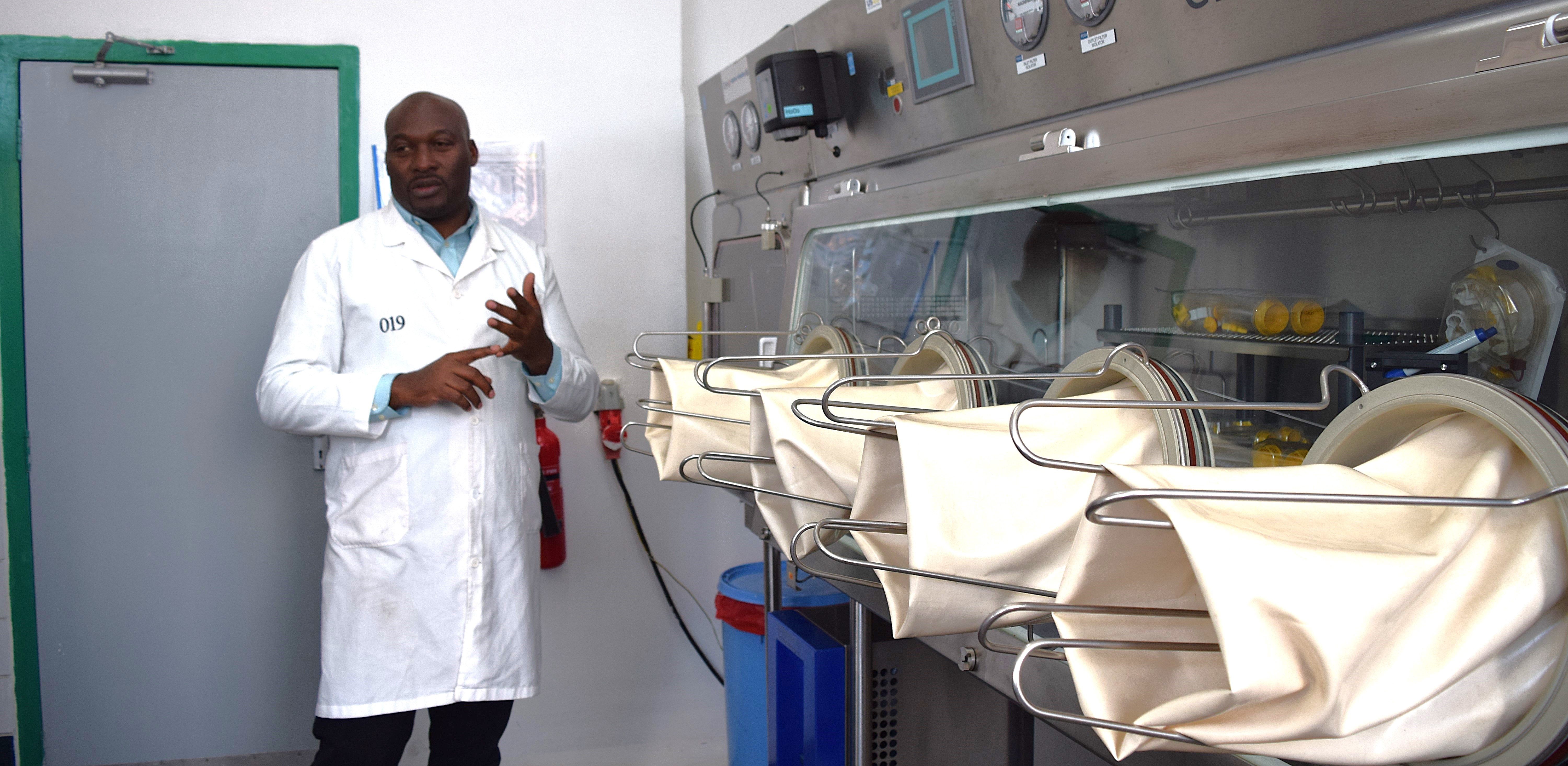 lab specialist stands near testing equipment in Kenya