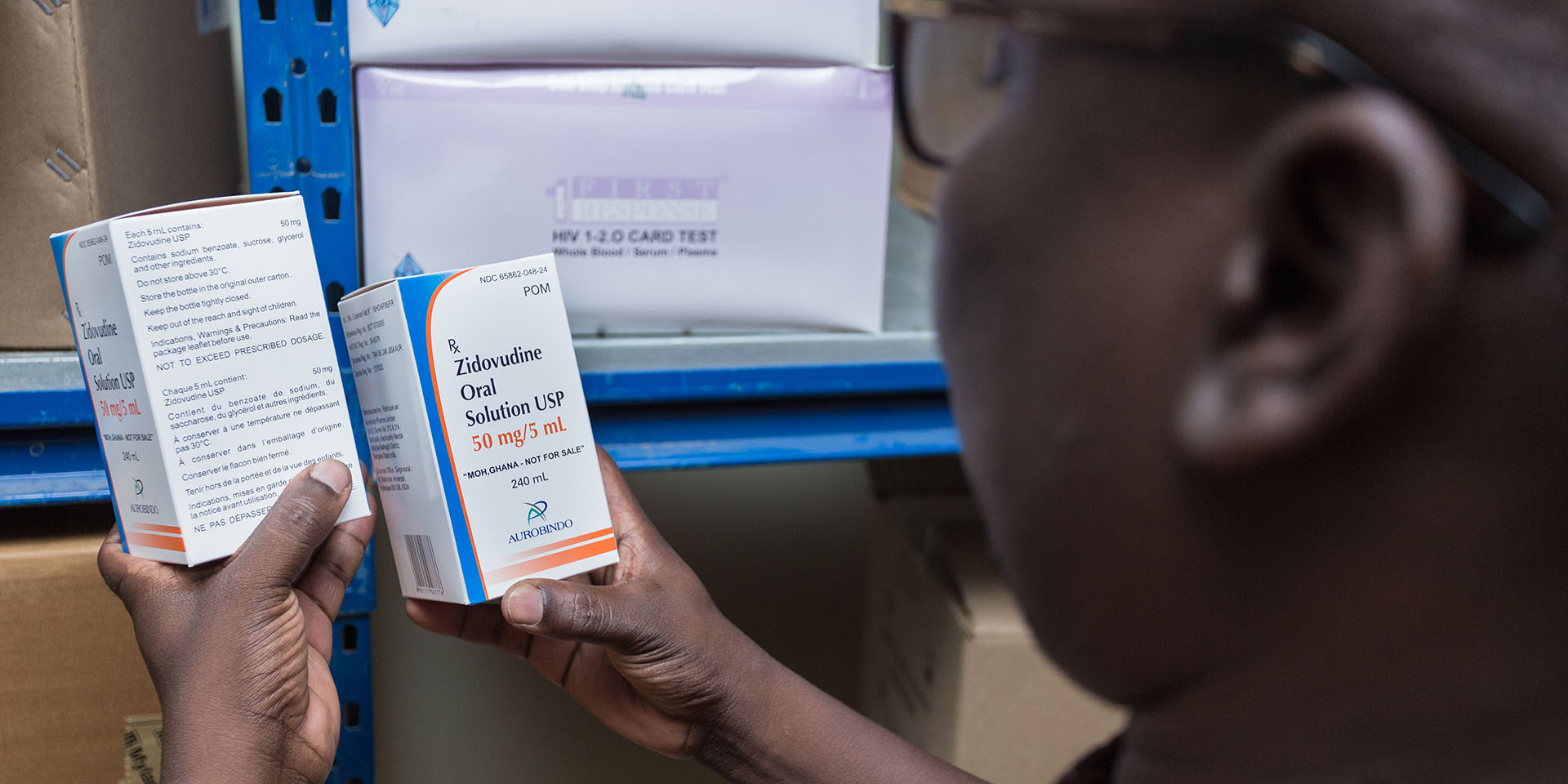 Someone holding up two boxes of Zidovudine Oral Solution