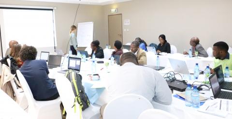 Burundi government and NGO workers discuss health supply planning in a large meeing room